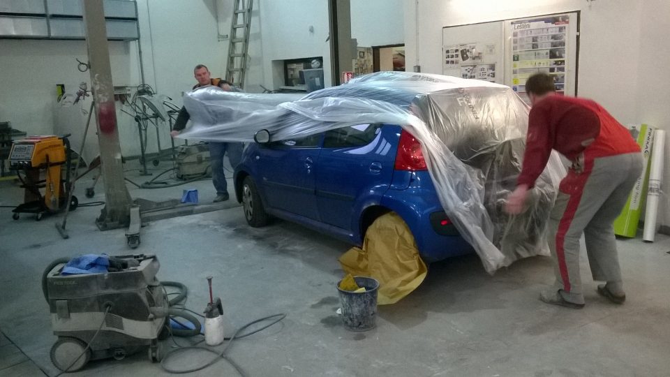 Ještě předtím ale musí lakýrníci celé auto zabalit do fólie. Lakovat se bude jen spodní část dveří, ne celé auto